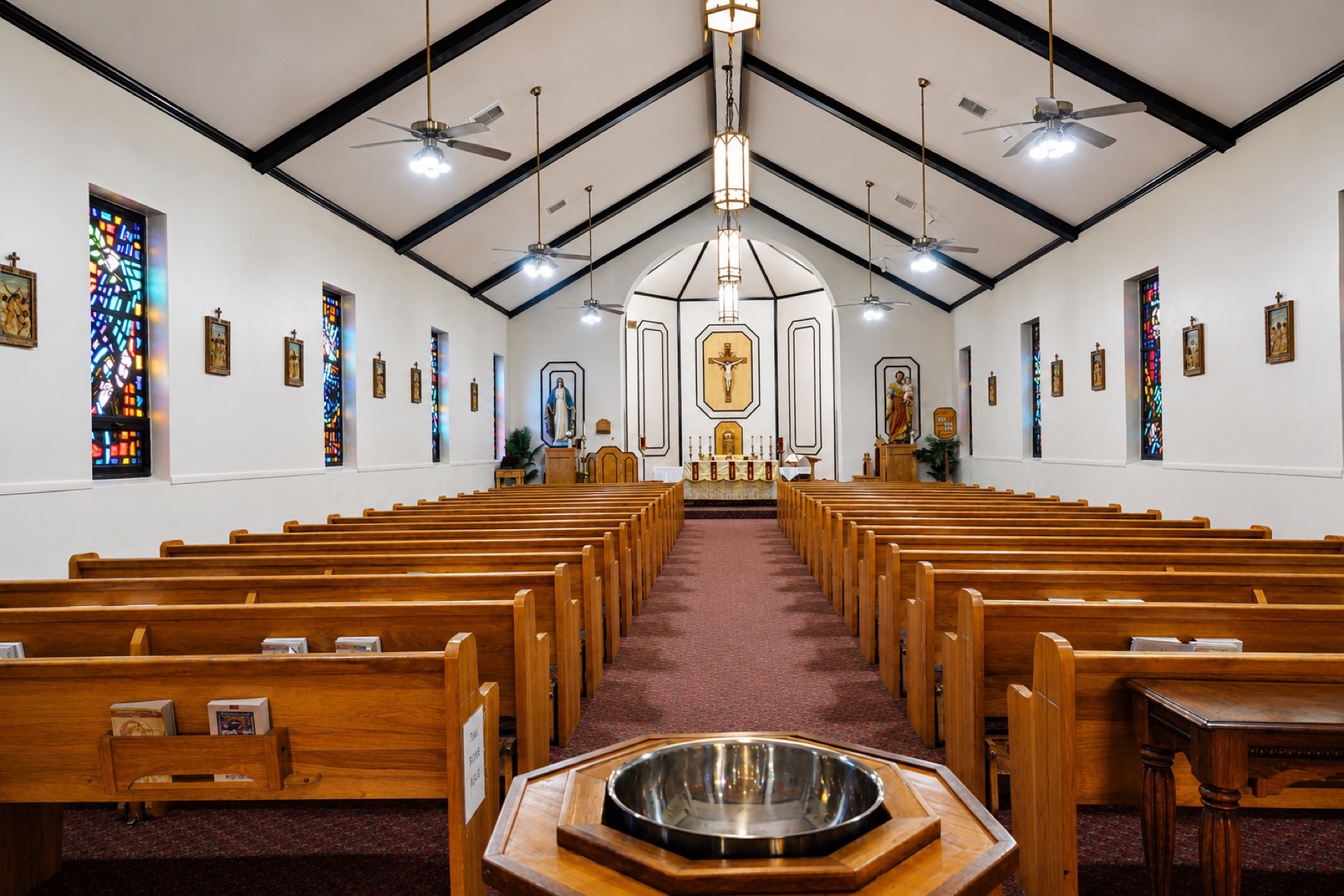 The nave, baptismal font, and sanctuary inside St. Ann Catholic Church