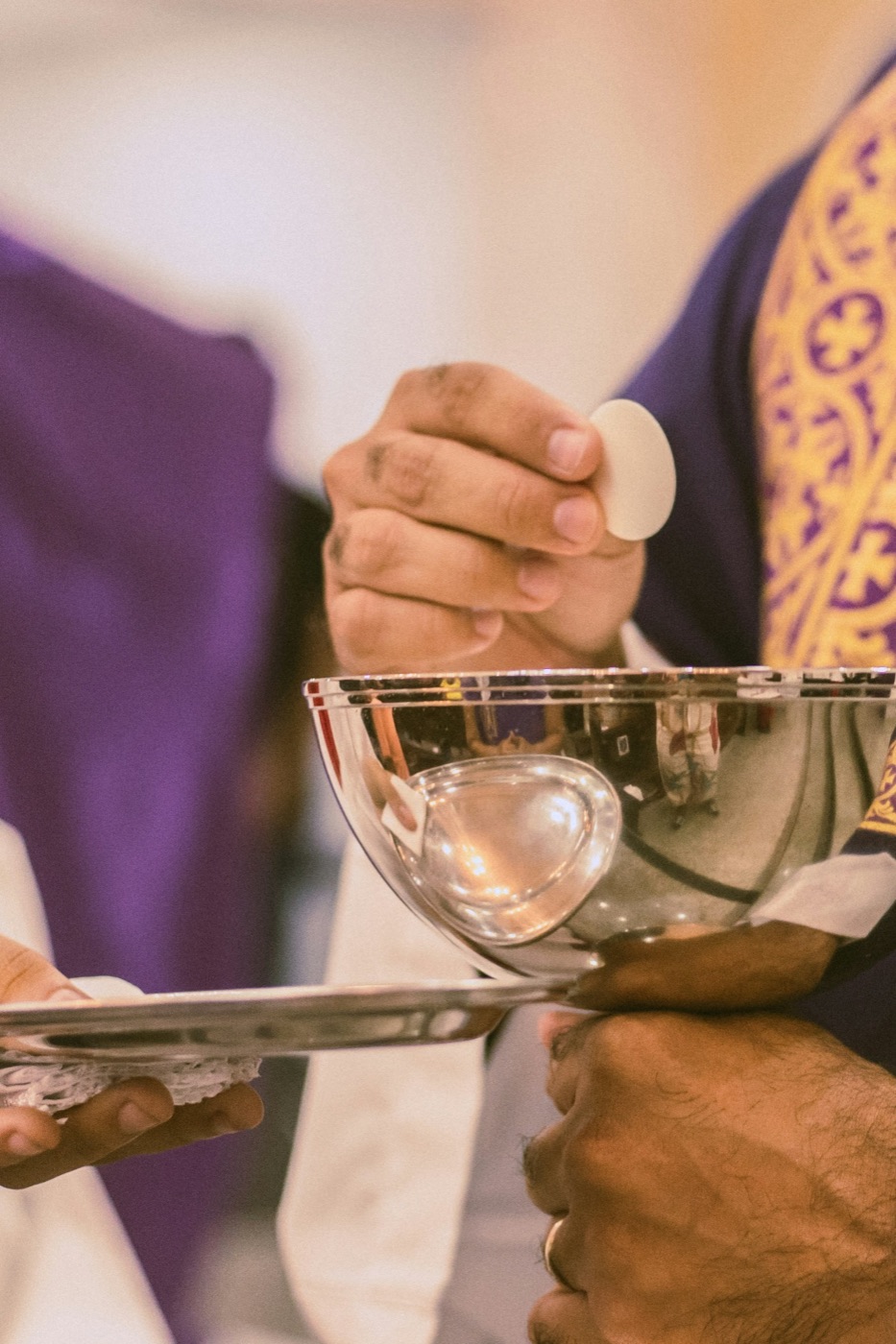 Priest holding the Eucharist above the chalice
