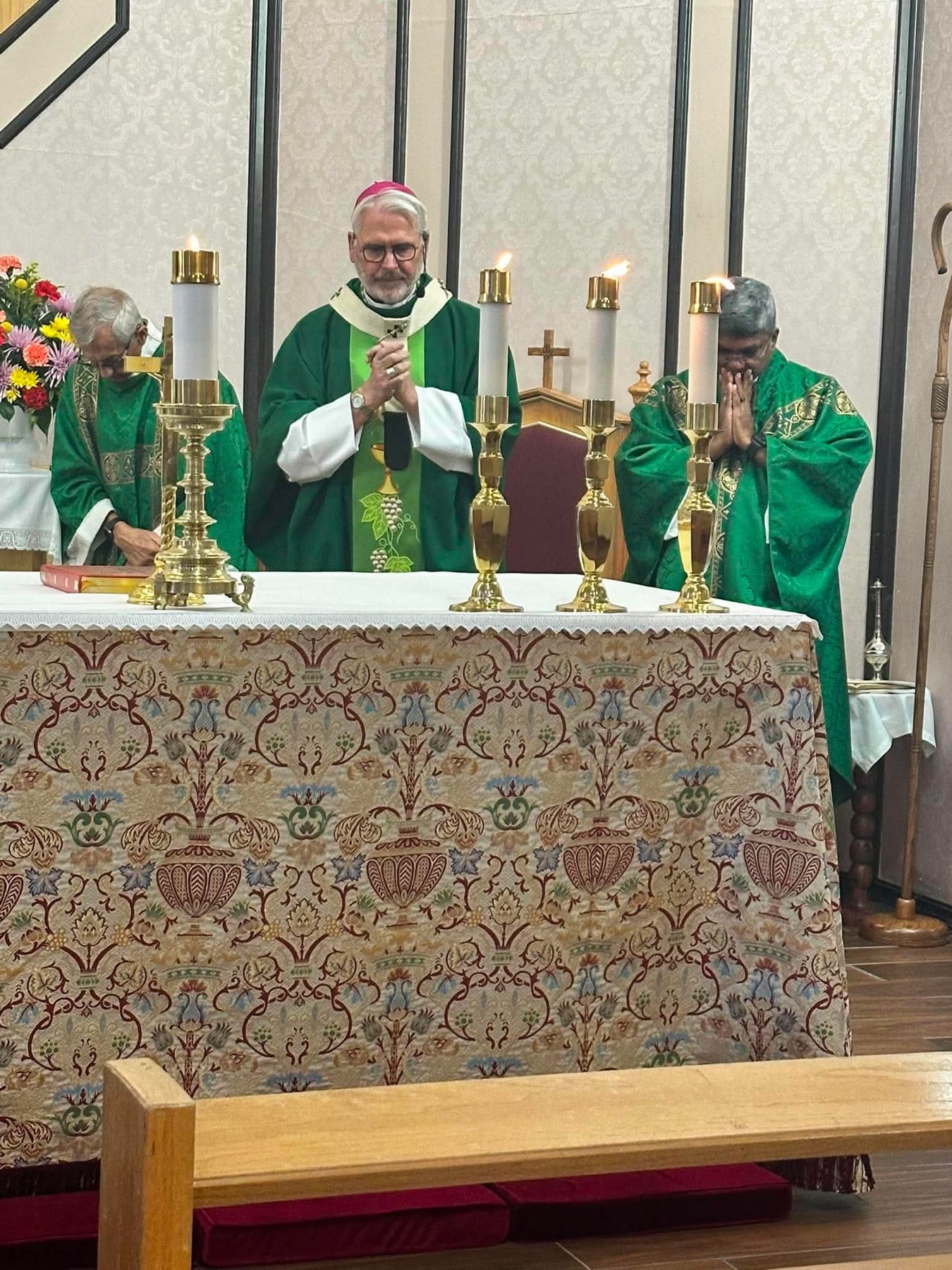 Archbishop Coakley and priests gathered at the altar during Mass